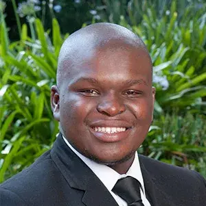 A headshot of Musa Madunge Mdunde, MD, with a serious expression, wearing a professional suit